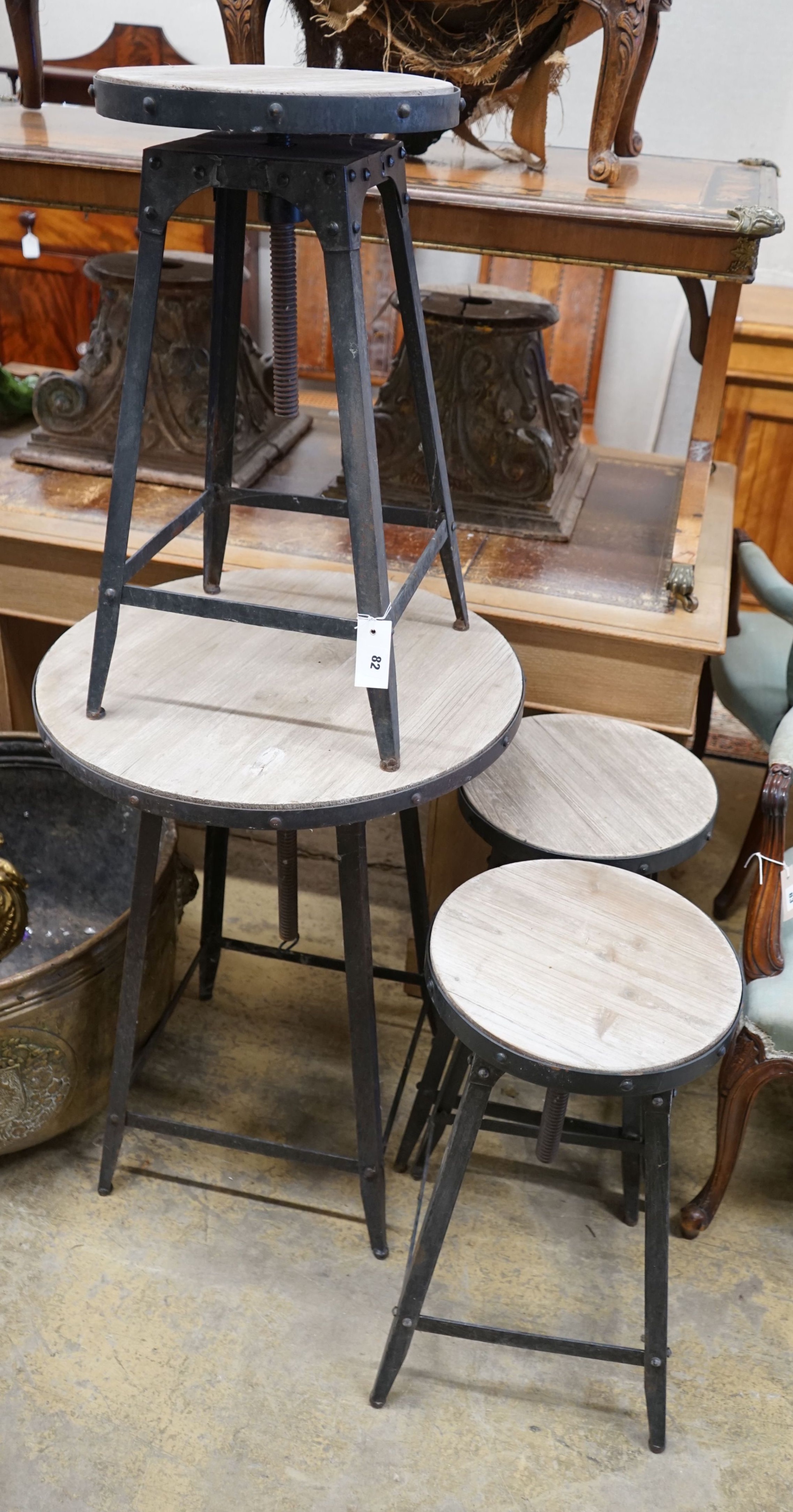 An industrial style circular adjustable table, diameter 60cm, together with three matching stools